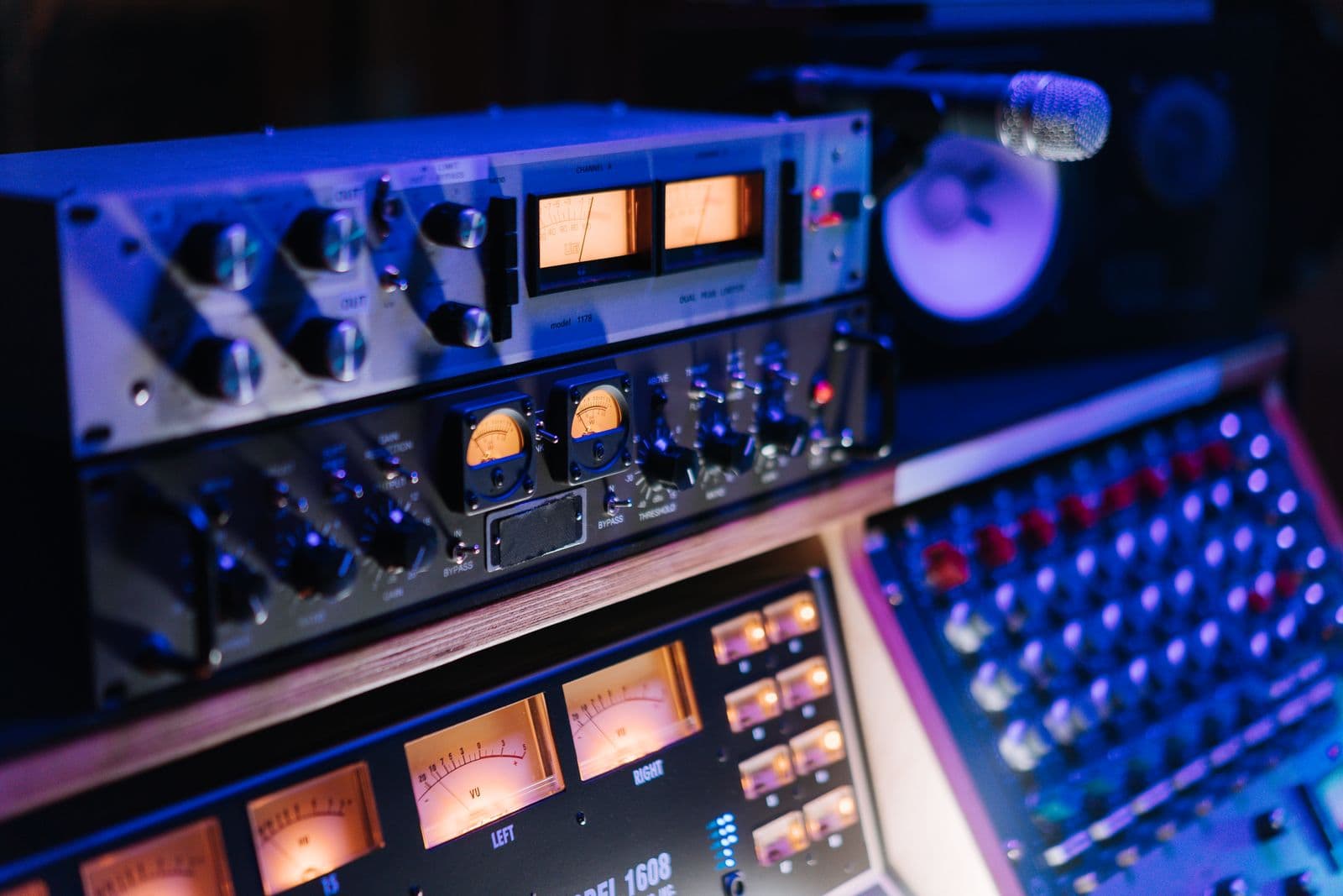 Outboard studio gear and VU meters lit in blue and violet