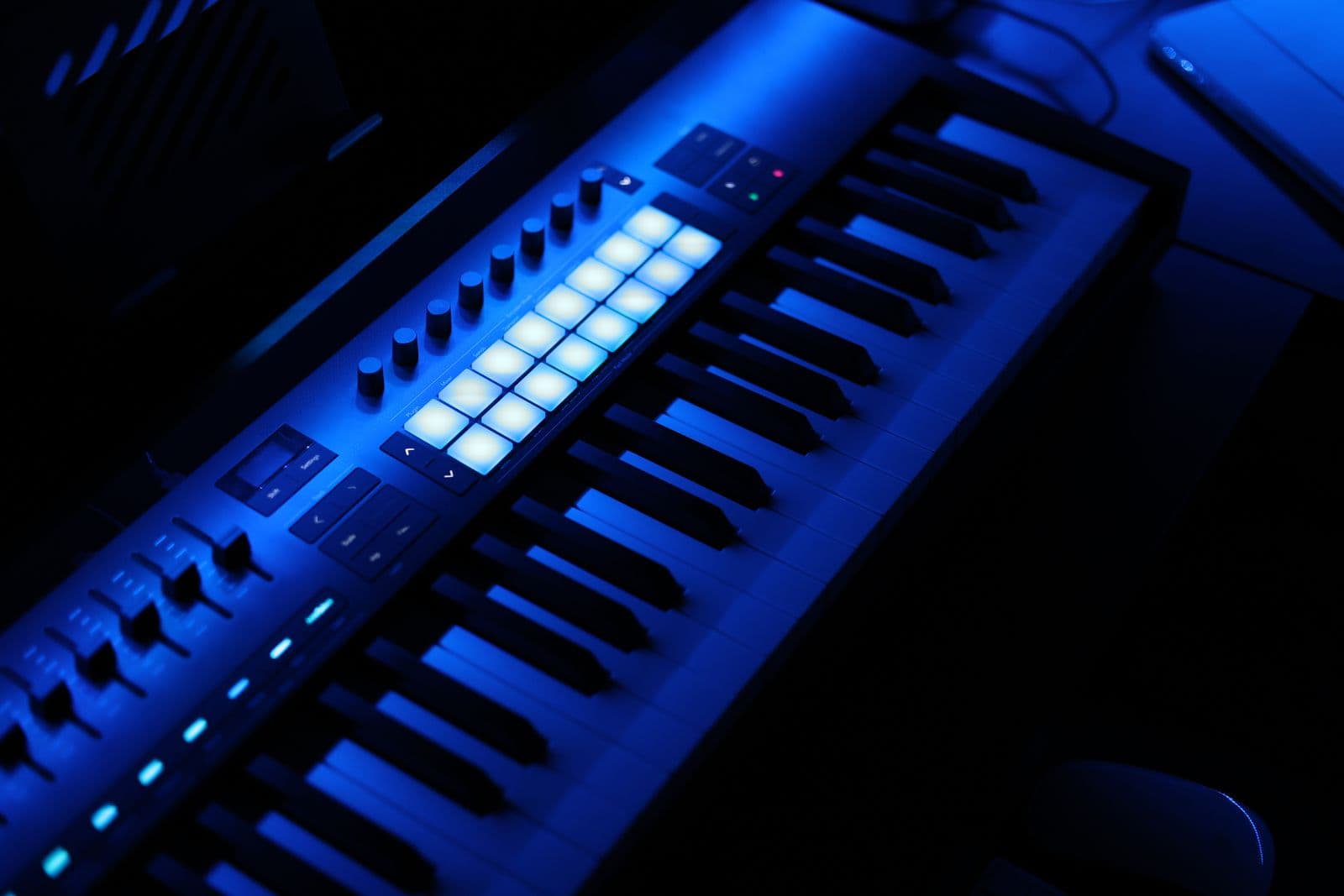 Producer hardware lit blue in a dark studio